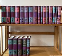 Front view of the 21 volume hardcover set showing color-coded spines with black etched illustrations and Oxford branding.