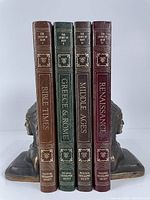 All four volumes upright between two bookends showing spines and titles.