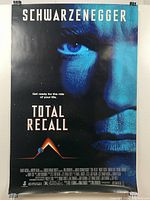 Front view of the 'Total Recall' movie poster featuring Arnold Schwarzenegger's face in blue tones.