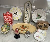 Complete lot of vintage and vintage-look chicken and egg themed kitchen and decorative items displayed on a counter.