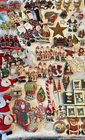 Over 100 assorted Christmas ornaments including multiple Santa Claus decorations, snowmen, angels, stars, and Hallmark miniature ornaments in boxes.