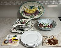 Photo showing the vintage dessert plates, MCM bowl, white embossed small plates and two decorative tiles