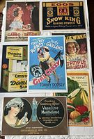 Seven vintage-style reproduction advertising prints displayed overlapping, featuring movie and food ads with colorful vintage designs.