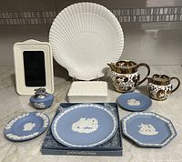 Photo showing all items including white picture frame, nautilus shell plate, two gold lusterware creamers, several Wedgwood Jasperware plates, lighter, ashtray