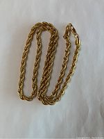 Full view of the gold plated rope chain necklace against a white background, showing the entire length coiled.
