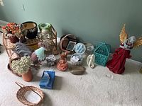 Wide shot showing many items including baskets, animal figurines, plant pots, and decorative pieces on carpeted floor.