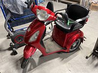 Full side-angle view of red 3-wheel electric trike scooter showing frame, handlebars, seat and wheels