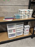 Stacked clear plastic drawer units on metal shelving with totes and felt sheets