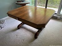 Overall view of walnut dining table showing rectangular top and carved double pedestals.
