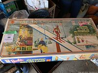 Box top showing Barbie Olympic Ski Village Ski Chalet playset with ski slope and skier figure in front.