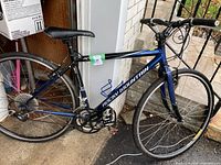 Right side profile of dark blue Rocky Mountain bike leaning against porch