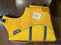 Photo of extra-large yellow dog life jacket showing front and side with adjustable straps and reflective piping