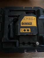 DeWalt electronic level placed in its molded plastic carrying case, showing the front side of the level with controls and branding.