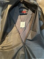 Hugo Boss gray soft stripe suit visible inside garment bag, size tag 134 present.