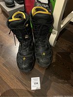 Front view of the pair of black Terra men's work boots with yellow lining, showing laces tied and boots standing upright.