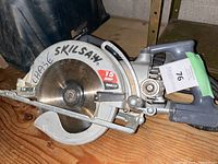 Photo shows a Chase Skilsaw circular saw with 15 amp motor, model SHD77. The saw looks lightly used and functional. The name 'CHASE SKILSAW' is handwritten on the blade guard.
