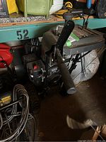 Full view of machine showing handles, chute, auger housing and wheels