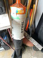 Front view of Stihl gas engine unit with black blower tube showing wear