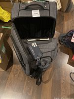Medium wheeled luggage piece with open main compartment showing interior.