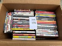 Box with approximately 75 DVDs in multiple stacked rows showing varied movie titles.