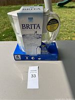 Front view of Brita water filter pitcher on top of blue box with packaging details visible.
