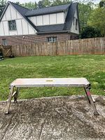 Full view of Gorilla Ladder aluminum work platform standing on concrete with grass background