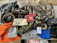 Photo of various purses including leather, fabric, mesh, and patterned designs arranged on the floor