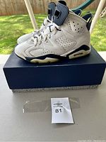 Side view of Jordan size 9 sneakers on top of their original box, showing overall condition and style.