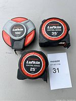 Photo of three Crescent Lufkin tape measures: 100 feet, 35 feet, and 25 feet lengths. Shows front labels and general condition.