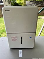 Front view of Toshiba dehumidifier showing Toshiba logo, water tank and level indicator