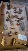 Overview photo of brass and faux brass small figurines arranged in a cardboard box showing various small decorative objects.