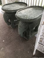 Pair of grey-green woven wicker elephant end tables shown side by side with removable tops. Both have detailed elephant features including ears and trunks, show aged wear.