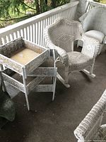 Image showing the full view of the vintage wicker rocker chair and matching swing-apart stand on a porch.