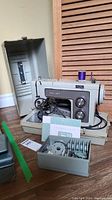Photo of vintage beige Sears Kenmore zig zag sewing machine model 1516 with hardshell case opened, foot pedal visible.