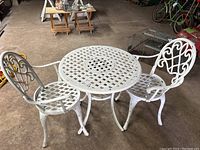 Overall view of white painted metal round table with two chairs