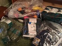 Clear plastic bags filled with assorted yarn skeins in multiple colors, brands visible include Premier Puzzle and Berroco Maxxim.