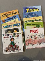 Photo of 10 Robert Munsch children's books arranged in two stacks, titles visible on most covers.