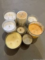 Top view of eight candles showing colors, wicks, and containers