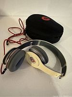 Beats By Dre headphones and carrying case displayed together. Shows overall condition and included items.