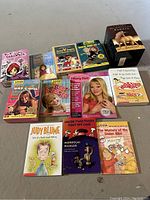 Wide view of the entire lot showing book titles, box sets and individual books arranged on floor