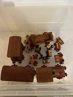 Overview of wooden train toy parts laid in a container.