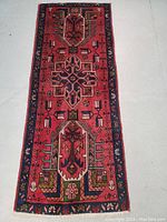 Full top view of runner showing red field, central geometric medallions, and blue guard borders.