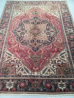 Full view of rug laid flat showing central medallion and border pattern