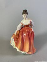 Front view of the Royal Doulton 'Fair Lady' porcelain figurine showing coral pink dress and facial details.