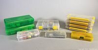 Multiple storage bins including green, clear with yellow latches, and yellow plastic boxes organized on surface.