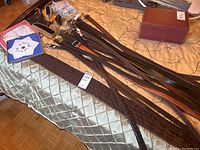 Overview of belts, shoe care brushes, and handkerchiefs laid out on fabric surface