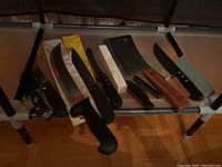 Photo showing the full row of nine cutting knives and two whetstones.