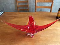 Front view showing the elongated red glass centerpiece with pointed ends and sculpted curves in the middle.