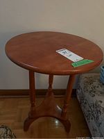 Front view of round wooden side table showing top surface and legs