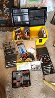 Photo of the open yellow and black Strong N Tuff toolbox and multiple tool sets laid out around it including screwdrivers, wrenches, ratchets, and power drill.